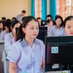 Group of high school students focused on learning in a computer lab setting.